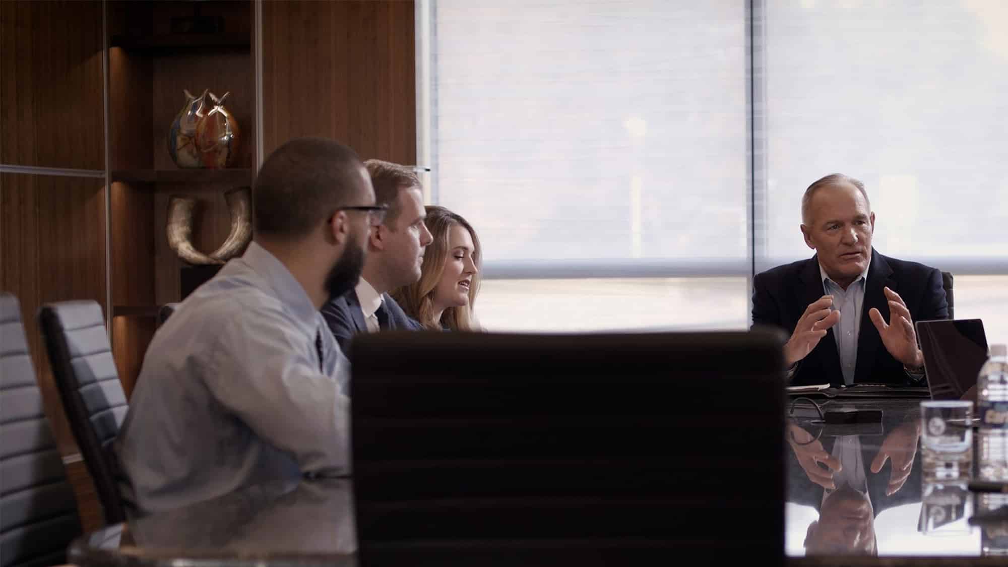 A diverse group of professionals sitting around a conference table discussing business strategies.